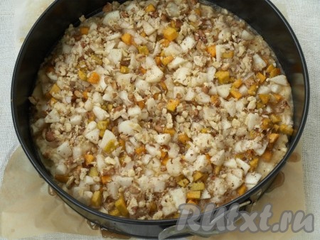 Взять разъёмную форму (у меня диаметром 24 см), застелить пергаментной бумагой. Аккуратно вылить тесто и разровнять. Сверху выложить начинку из яблок и тыквы, посыпать рубленными грецкими орехами.