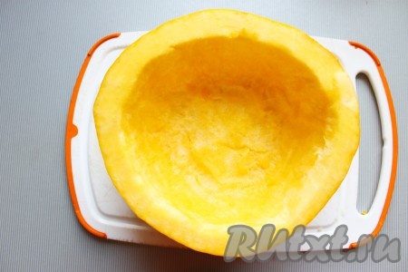 Тыкву хорошо вымыть, разрезать на две части (нам потребуется только одна часть, другую часть можно использовать для других блюд), очистить от семян. Для устойчивости "горшочка" подрезать донышко с внешней стороны.