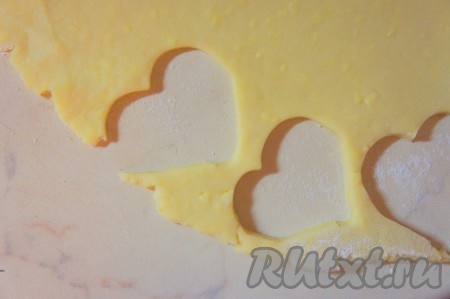 Рабочую поверхность присыпать мукой, раскатать тесто. Толщина раскатывания теста зависит от ваших вкусовых предпочтений: хотите более нежные сырное крекеры с влажной серединкой, тогда толщина раскатанного теста должна быть от 0,3 сантиметра, если же хотите, чтобы крекеры были хрустящими, тогда раскатывайте тесто потоньше. С помощью формочек вырезать из раскатанного теста заготовки сырных крекеров.