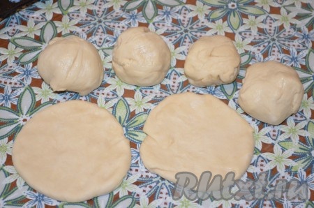 Тесто разделить на одинаковые кусочки. У меня вышло 6 кусочков, то есть я сформировала 6 крупных ватрушек. Можно разделить тесто и на большее количество частей, тогда и ватрушек получится больше, но они будут меньшего размера. Каждый кусочек теста скатать в шарик. Каждый шарик раскатать (или растянуть руками) в круглую лепёшку.&nbsp;Накрыть полотенцем и оставить на 40 минут.