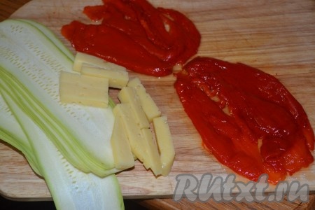 Кабачки нарежьте тонкими полосками, а твердый сыр - брусочками. Мякоть перцев нарежьте полосками.
