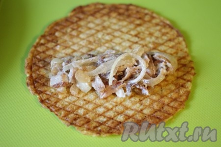 На вафлю выложить мясную начинку, свернуть рулетиком и порезать на три части.