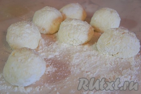 На рабочую поверхность насыпать 1 столовую ложу муки. Тесто разделить на 6-8 равных частей, скатать руками шарики и каждый обвалять в муке со всех сторон. Лучше всего обваливать сырники в муке влажными руками, тогда тесто не так сильно будет прилипать к рукам.