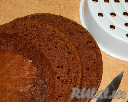 Готовому бисквиту дать остыть в течение 5 минут. Затем вынуть бисквит из чаши мультиварки с помощью накладки для варки на пару. Если выпекали в духовке, то просто достаньте бисквит из разъёмной формы. Полностью остудить бисквит, а затем разрезать его на 3 коржа.