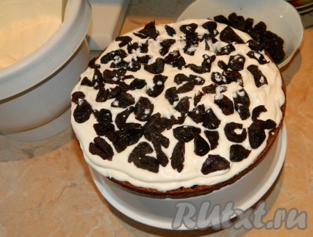 Пока остывает бисквит, нужно чернослив выложить в небольшую ёмкость, залить его кипятком минут на 5. Затем кипяток слить, разложить чернослив на бумажном полотенце, дать ему обсохнуть, после этого нарезать на средние дольки. Для приготовления крема нужно&nbsp;миксером взбить сметану с сахарной пудрой до однородной массы (долго взбивать не надо). Промазать коржи сметанным кремом, выкладывая на крем нарезанный чернослив. Верхний корж и бока торта "Тёмная ночь" тоже смазать сметанным кремом, но без чернослива.