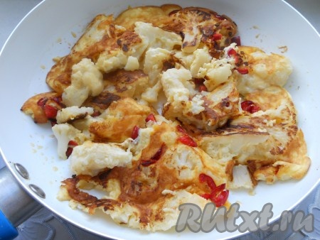 Накрыть сковороду крышкой, жарить цветную капусту с яйцом на самом минимальном огне до румяной корочки снизу. После этого капусту частями перевернуть на другую сторону и жарить еще минуты 2-3.&nbsp;
