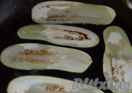 Баклажаны нарезаем тоненькими длинными пластинами и на разогретом растительном масле обжариваем с двух сторон.
