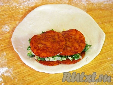 На раскатанные кусочки теста ближе к краю выложила по 2 тонких ломтика пепперони, приготовленную сырную массу, накрыла ещё двумя ломтиками колбасы.