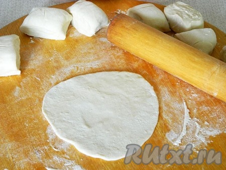 Разделила его на равные кусочки размером, как на пирожки. Раскатала каждый из них.