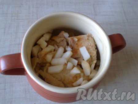 Добавляем яблоко, очищенное от сердцевины и кожуры, нарезанное кубиками (на каждый горшочек по четвертинке яблока).
