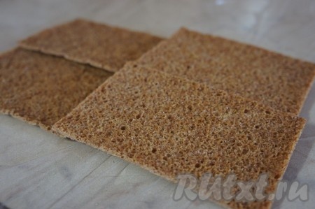 Получившуюся творожную массу намазать на хлебцы и можно подавать к столу. Я решила сделать оригинальные бутерброды. Для этого 4 хлебца нужно выложить внахлёст на пищевую плёнку, как на фото. Смочить хлебцы 150-200 миллилитрами кипячёной воды.