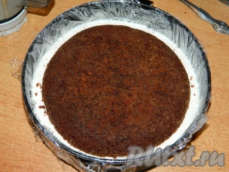 Затем на застывший крем выложить второй корж (если второй корж положить на не застывший крем, то корж начнёт тонуть). Если оставшийся крем начал густеть, его нужно слегка взбить блендером и сразу вылить на второй корж. Убрать торт в холодильник для полного застывания.
