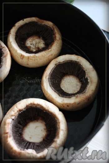 В форму, смазанную оливковым маслом, выкладываем шляпки шампиньонов и отправляем на 15-20 минут в разогретую духовку при температуре 170-180 градусов.
