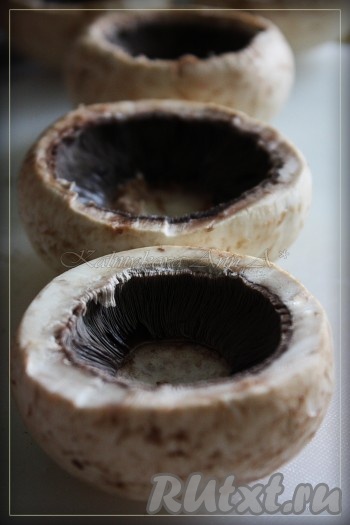 Удаляем у шампиньонов ножку. Ножку можно порезать, обжарить и добавить в начинку или заморозить (я их не использовала).
