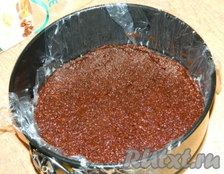 Дно формы застелить пищевой плёнкой (у меня форма диаметром 18 см). Выложить шоколадно-рисовую массу, разровнять и убрать в холод.
