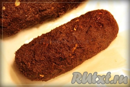 Выстилаем дно формы пищевой пленкой и разравниваем смесь или просто формируем шоколадную колбаску и заворачиваем в пекарскую бумагу. Закрываем десерт со всех сторон и ставим на 1 час в холодильник.