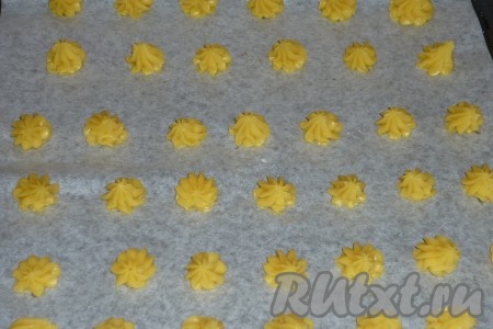 Наполняем полученным тестом кондитерский шприц и выдавливаем на противень, застеленный бумагой для выпечки, небольшие шарики.
