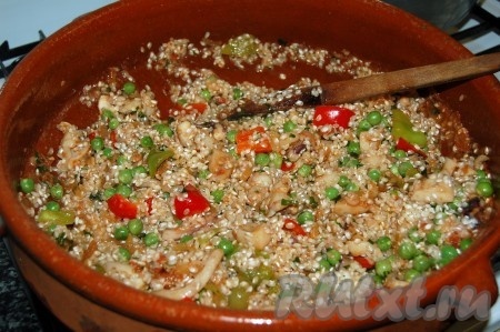 Рис выкладываем в сито, промываем, лишней воде даём стечь. Подготовленный рис тоже отправляем в сковороду. Тщательно перемешиваем содержимое сковороды.