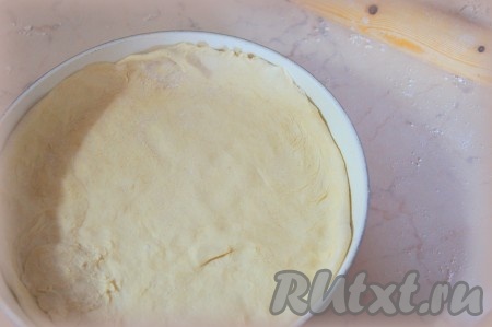 Тесто разделить на две части. Рабочую поверхность посыпать мукой, раскатать одну часть теста так, чтобы она было чуть больше диаметра сковороды, застелить им дно сковороды.
