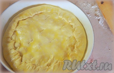 Аккуратно защипнуть края, смазать верх пирога взбитым яйцом, сделать несколько наколов вилкой.