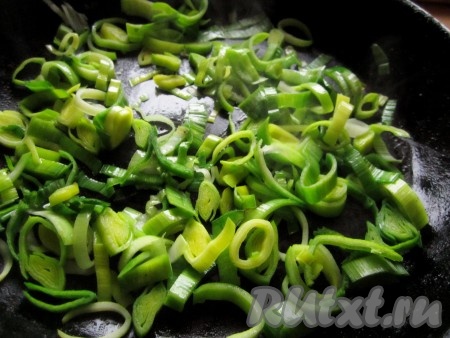 Сначала приготовим начинку. Лук-порей нарежьте тонкими колечками. В сковороде разогрейте масло и слегка обжарьте лук.
