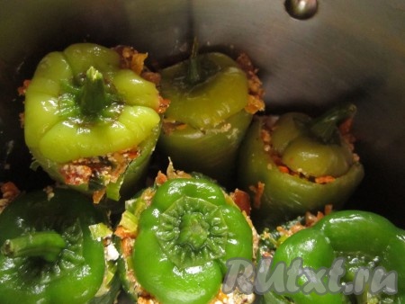 Поставьте фаршированные перцы вертикально в кастрюлю соответствующего диаметра так, чтобы они не падали на бок. Сверху прикройте каждый перец "крышечкой".
