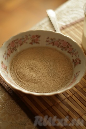 Подогреть 100 миллилитров воды примерно до 38-40 градусов (если вода будет более горячей, дрожжи в ней погибнут), перелить в глубокую тарелку, всыпать сахар, перемешать, добавить дрожжи, снова перемешать и оставить на 10 минут. За это время дрожжи начнут работать и поверхность дрожжевой смеси покроется пенной шапочкой.