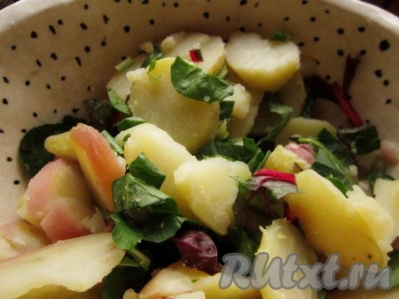 Когда картофель будет готов, дать ему немного остыть, чтобы легче было его чистить и резать. Очистить картошку от кожицы и нарезать тонкими кружочками. Перемешать с листьями салата (мангольда).