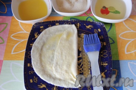 Обильно смазываем получившийся пласт сливочным маслом (масла не жалеем) и слегка присыпаем манкой. Один край теста подворачиваем к центру и также смазываем сливочным маслом, присыпаем слегка манкой. Подворачиваем к центру второй край теста, смазываем его сливочным маслом и присыпаем манкой.
