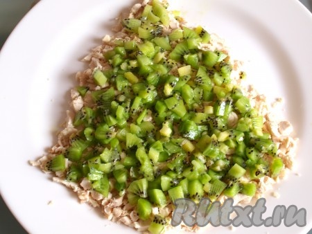 На тарелку в форме ёлочки выкладываем куриное филе, нарезанное кубиками. Затем выкладываем 2 киви, очищенных от кожуры и порезанных кубиками.&nbsp; 