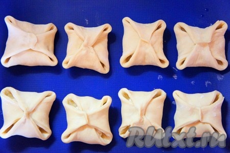 Аналогичным образом свернуть оставшиеся слойки. Противень застелить бумагой для выпечки или силиконовым ковриком, выложить булочки.
