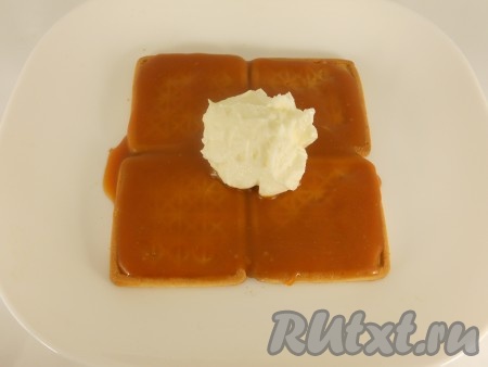 Печенье (4 штуки) выложить на тарелку. Смазать карамельным соусом, сверху смазать творожным кремом. Разровнять.
