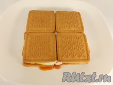 Далее, таким же образом, выложить остальное печенье (еще 3 слоя), промазывая каждый слой карамельным соусом и творожным кремом.
