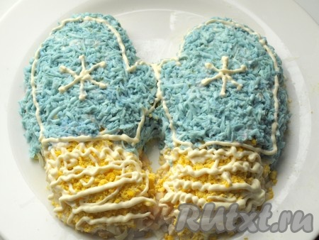 Выложить верхнюю часть варежек окрашенными белками. Майонезом нарисовать снежинки.
