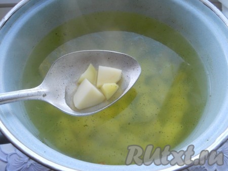 Кастрюлю с куриным бульоном поставить на огонь. После закипания куриного бульона выложить в него картофель, куриное мясо, снова дать закипеть и варить на небольшом огне до полуготовности картошки (минут 10).