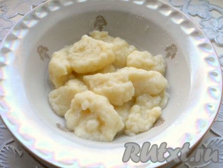 Далее в небольшой кастрюле вскипятить воду, посолить, уменьшить огонь. Чайную ложку опустить в кастрюлю с закипевшей водой, затем набрать часть теста этой чайной ложкой и сразу поместить её в кастрюлю с водой, помогая, если необходимо, снять тесто второй чайной ложкой. Таким образом в кастрюле окажется первая галушка. Одну за другой сформировать все галушки из оставшегося теста, дать воде закипеть и отварить галушки с момента закипания на небольшом огне в течение 4-5 минут. Готовые галушки переложить на тарелку.