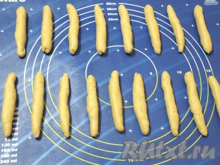 В муку, просеянную с разрыхлителем, добавляем 2 столовых ложки сахара, ванилин, соль и размягченное сливочное масло. Вливаем тёплую воду и замешиваем мягкое, гладкое тесто. Из теста формируем палочки длиной около 10 см и толщиной 1 см, зауженные по краям.

