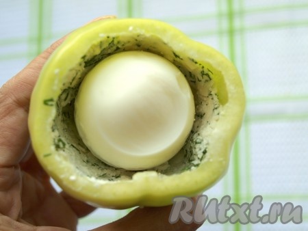 Положить в середину каждого перца по целому очищенному яйцу и оставшееся пространство заполнить начинкой.
