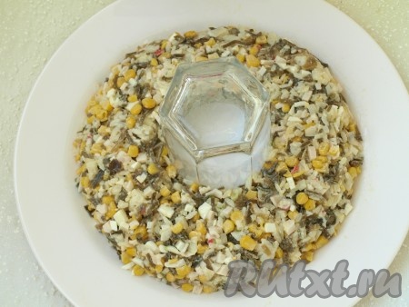 Ставим в центр тарелки стакан и выкладываем вокруг него салат в форме кольца.
