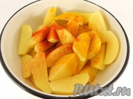 Картофель очистить, нарезать на средние дольки, посолить, посыпать специями, хорошо перемешать и выложить в сковороду, в которой обжаривалась свинина. Если нужно, влить ещё немного масла.