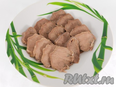 В тарелки или судочки выложить свиной язык, нарезанный на кусочки.