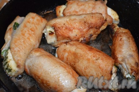 На сковороду с разогретым растительное масло выложить рулетики и обжарить их со всех сторон до золотистой корочки на среднем огне.