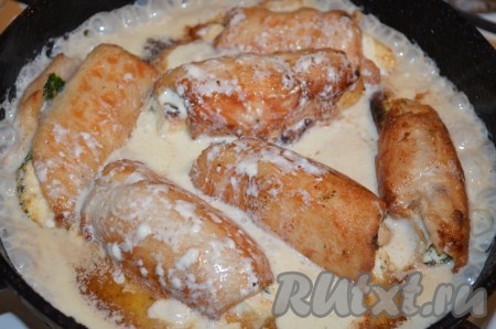 Пока они жарятся, приготовить соус. Для этого смешать сметану, майонез, муку, тёплую воду, соль и сахар. Залить куриные рулеты получившимся соусом, довести до кипения, уменьшить огонь и протушить под крышкой 1-2 минуты. За это время один раз рулетики нужно перевернуть, чтобы они протомились в соусе со всех сторон. Убрать сковороду с огня.