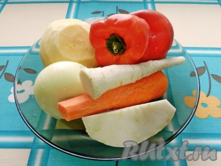 Репу, морковь, лук, корни петрушки и сельдерея очистить. Удалить плодоножку и семена из болгарского перца. Подготовленные овощи промыть водой.