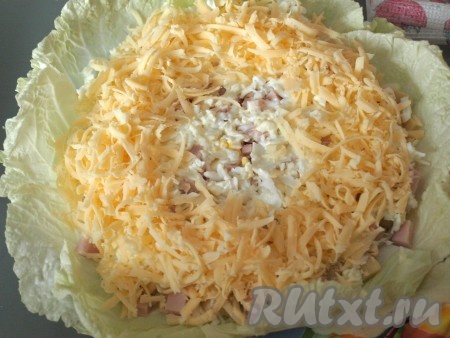 Натереть на тёрке половину твёрдого сыра, выложить его поверх белков в форме кольца.