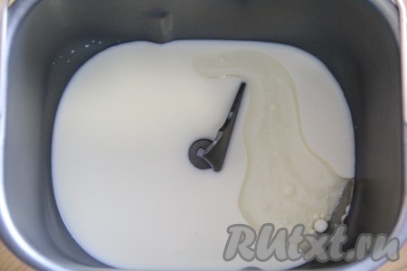 В ведёрко хлебопечки наливаем тёплое молоко и растительное масло, добавляем сахар.
