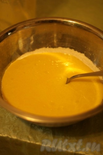 Затем тонкой струйкой, также не прекращая взбивать миксером, влить растительное масло. Получившуюся смесь вылить в глубокую миску. Добавить соду и половину муки. Перемешать лопаткой (или столовой ложкой) и начать подсыпать оставшуюся муку, каждый раз полностью вмешивая её в тесто. Итоговое тесто должно получиться, напоминающим сметану средней жирности, оно будет лентой стекать с лопатки (или ложки). Муки может потребоваться чуть больше или чуть меньше, главное - учитывайте консистенцию замешиваемого теста для пирога.