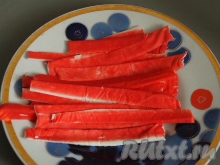 Отрезать красную часть от крабовых палочек и отложить для оформления.
