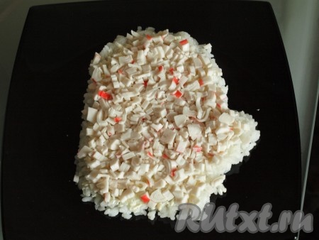 Белую часть нарезать кубиками и выложить поверх риса.
