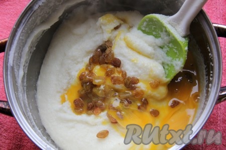 Яйца разделить на желтки и белки. Манную массу слегка остудить и добавить к ней измельченный миндаль, изюм и яичные желтки.
